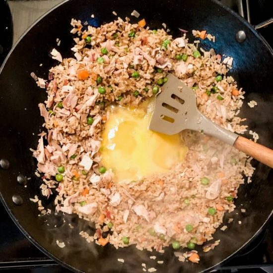 adding eggs to rice in skillet