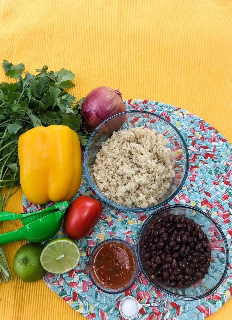 Ingredients for Mexican Quinoa with quinoa black beans salsa salt lime tomato pepper and onion