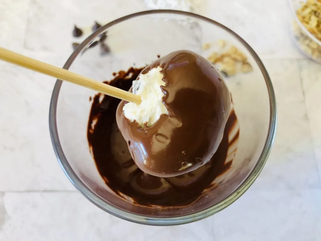 coconut ball dipped into melted chocolate