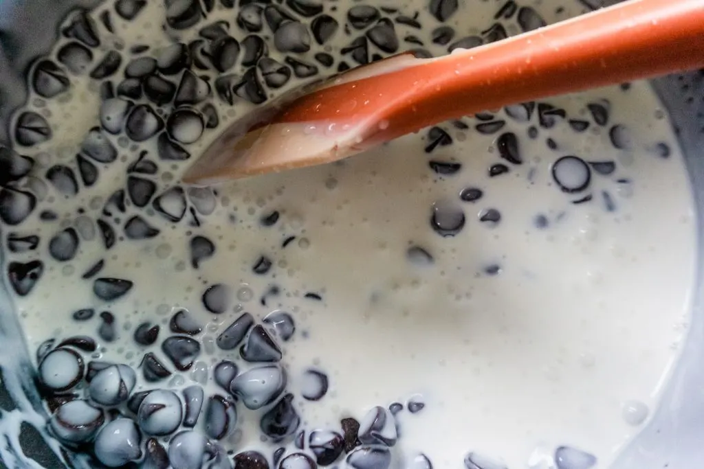 melting chocolate chips with cream in saucepan