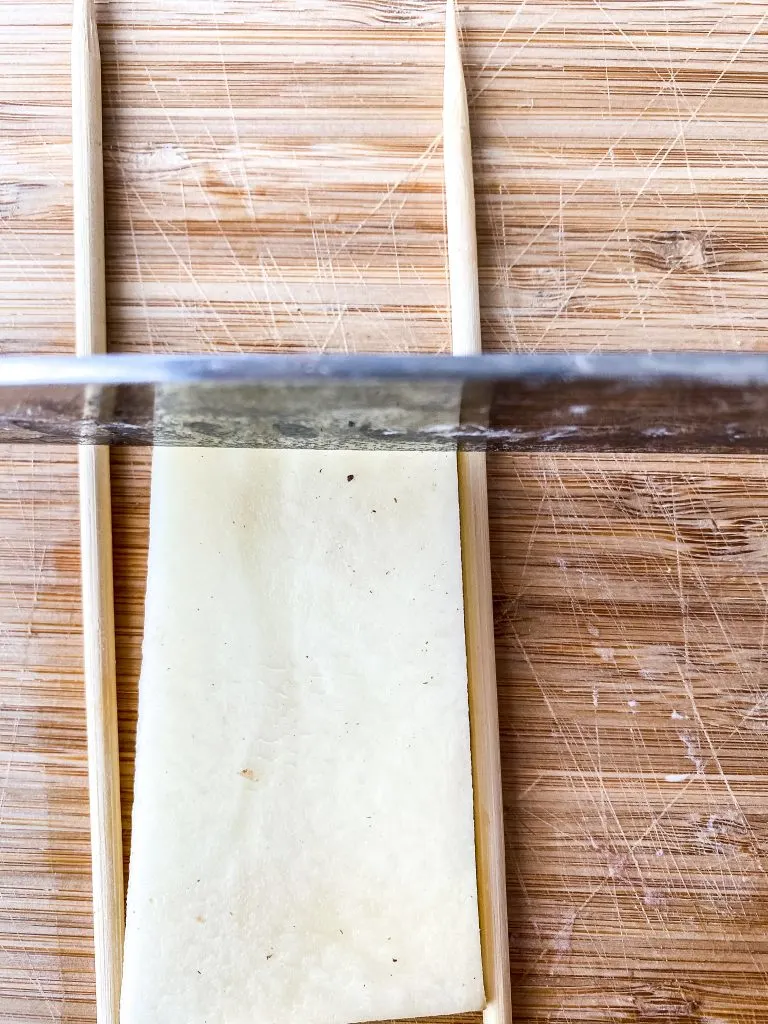 horizontal cuts on potato between skewers