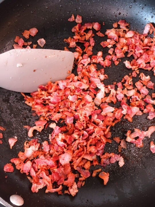 diced bacon cooking in pan