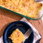 casserole dish of cheddar bacon polenta squares with one square plated
