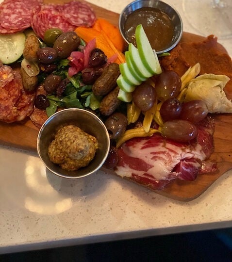 Parched Pig Charcuterie Board with meats pickles and olives