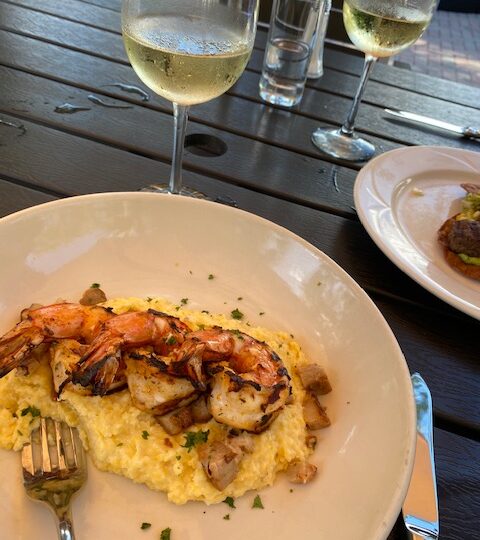 Shrimp and Grits with glass of wine at The Kork