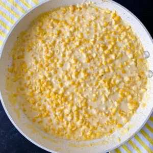 skillet of gluten free southern creamed corn recipe ready to serve with yellow striped towel