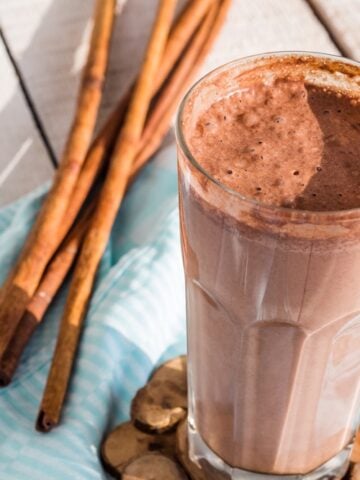 gluten free protein shake with chocolate, banana, peanut butter and cinnamon on blue cloth