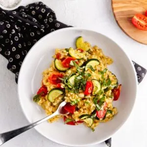 plated gluten free vegan risotto with salt basil and tomatoes
