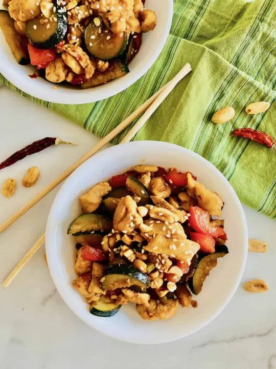 keto kung pao chicken in bowls with chopsticks