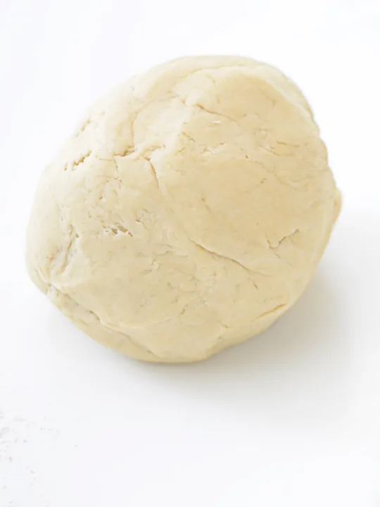 ball of gluten free pretzel dough on white surface