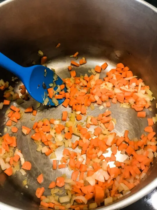 cooking carrots onion and other vegetables for vegetable soup with orzo