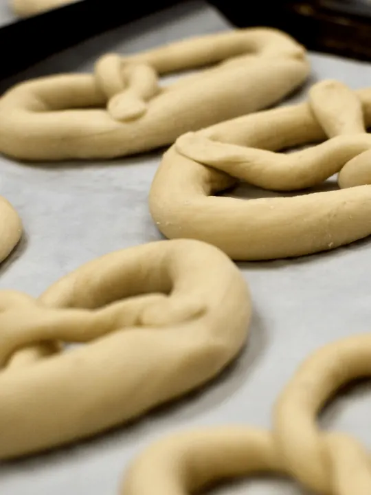 gf pretzels on parchment paper on baking sheet before baking