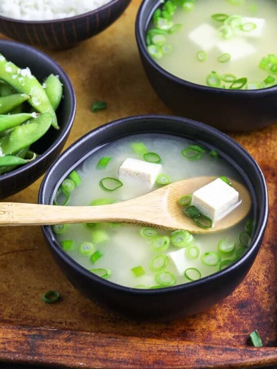 vegan miso soup with wooden spoon on wooden platter
