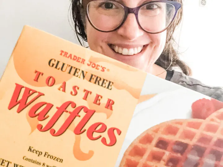 Sharon holding a box of Trader Joe's Gluten Free Toaster Waffles with freezer in background
