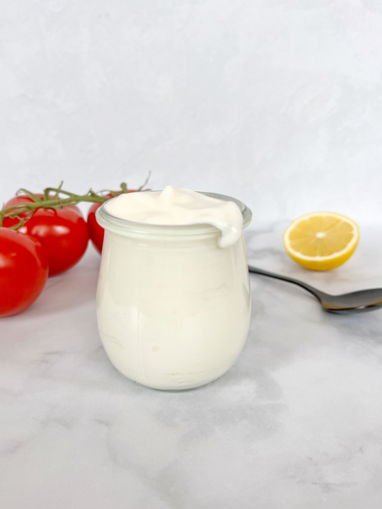 jar of gluten free vegan homemade mayo with tomato and lemon