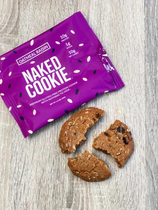 broken oatmeal raising naked cookie with wrapper on wooden table