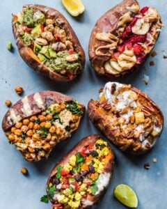 baked sweet potatoes with five different toppings, lemon wedge, and lime wedge