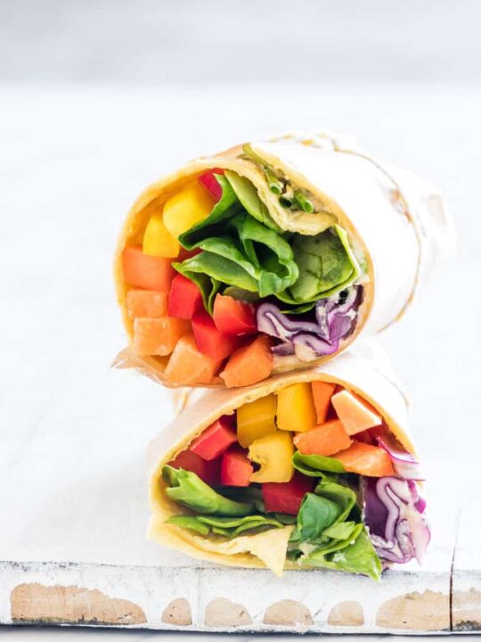 gluten free wrap filled with rainbow veggies on wooden plank