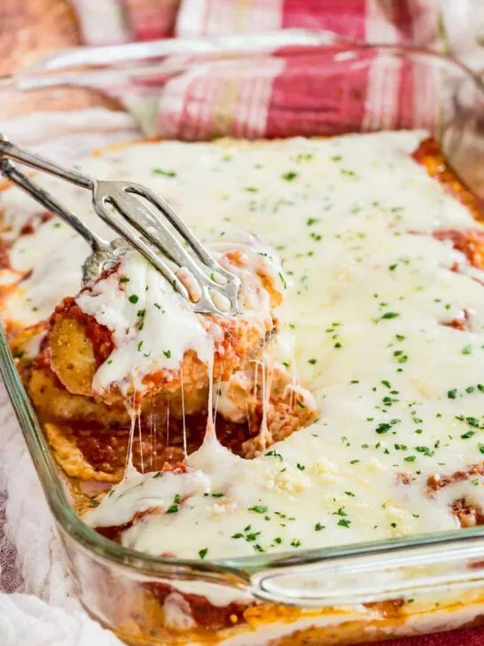 gluten free chicken parmesan in baking dish being served with tongs