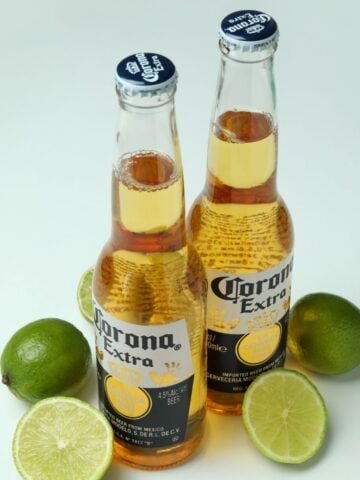 bottles of corona on table with limes