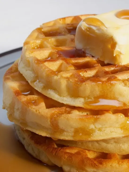 4 gluten free frozen waffles stacked with butter and syrup