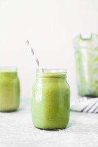 avocado and moringa green smoothie in mason jar with striped straw