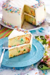 slice of two layer gluten free funfetti cake with white frosting