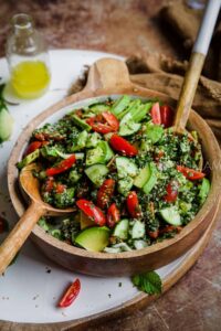 gluten free vegan taboule salad in bowl topped with cucumber and tomato