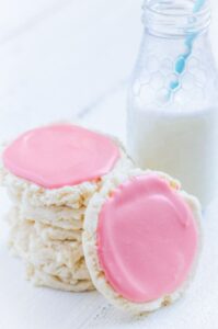stack of gluten free swig cookie copycats with pink frosting and jar of milk with blue straw