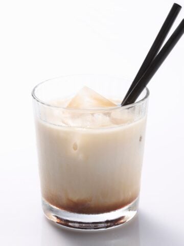 kahlua and milk in glass with black stirrers