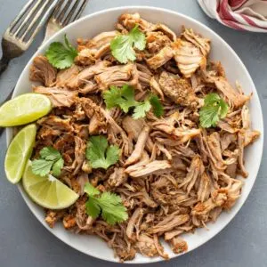 shredded gluten free carnitas made in an instant pot with cilantro and limes
