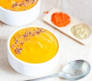 bowl of spiced carrot lentil soup with spoon
