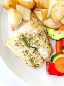 air fried frozen cod on plate with veggies and potatoes