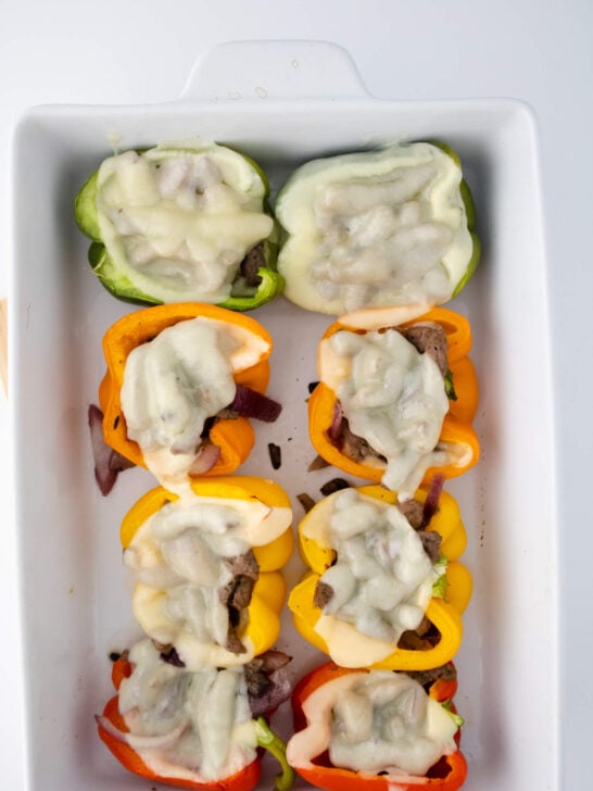 baked philly cheesesteak stuffed peppers in white baking dish