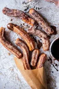 low fodmap gluten free churros in brown paper with chocolate sauce