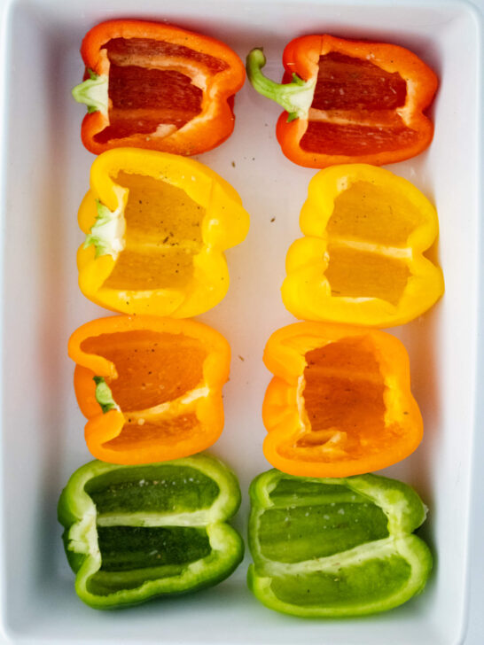 8 halved bell peppers in white baking dish