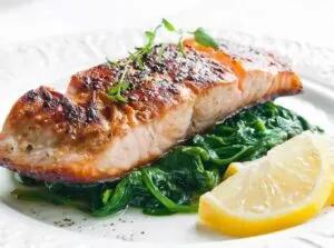 salmon on top of spinach and lemon