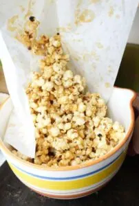 homemade vegan caramel popcorn pouring into bowl