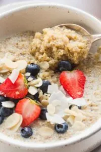 quinoa porridge topped with coconut flakes, almonds, and berries