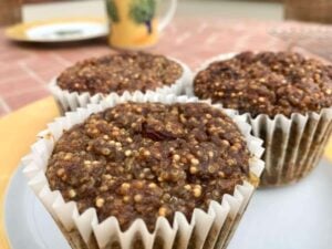 quinoa muffins in paper muffin wrappers on a white and yellow plate
