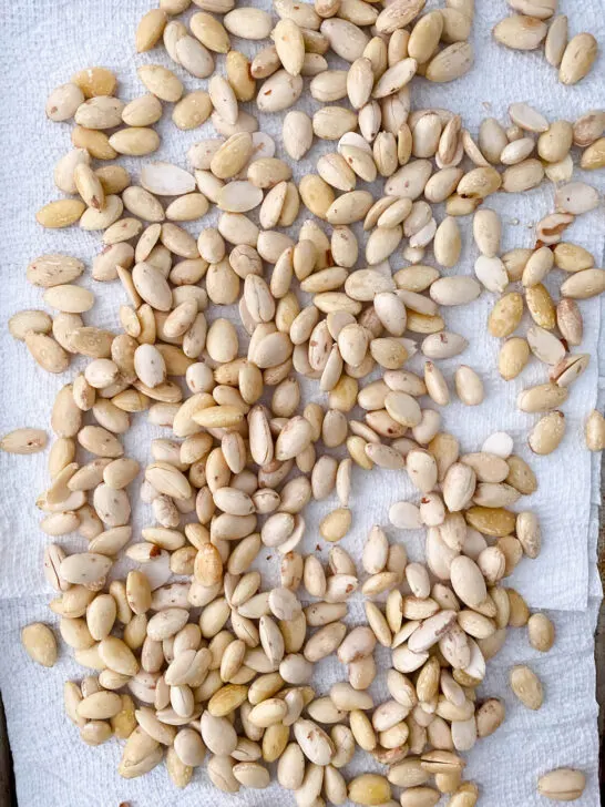 blanched and peeled almonds drying on a paper towel towel