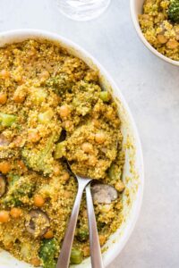 curried coconut quinoa bake with chickpeas in casserole dish with small bowl on side
