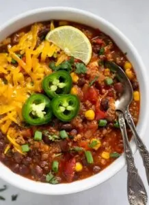 vegetarian quinoa chili in bowl topped with cheese and jalapeno