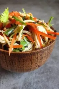 enoki mushroom salad in wooden bowl