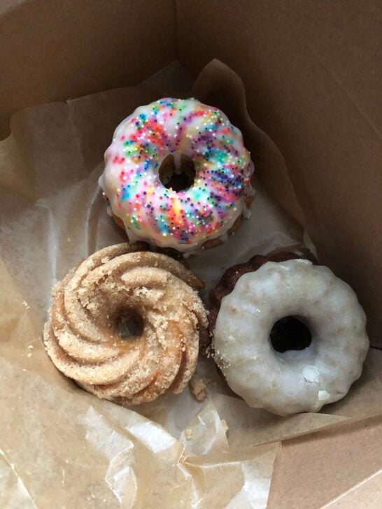 three gluten free donuts in cardboard box from By The Way Bakery in NYC