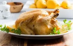 low carb pollo al limone whole roasted chicken on plate with lemon wedges