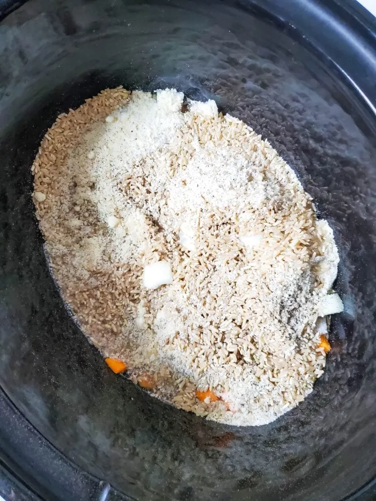 butternut squash, onion, brown rice, parmesan, and seasonings in slow cooker insert
