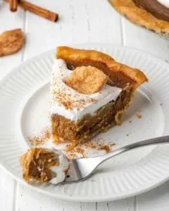 apple butter pie topped with whipped cream on white plate with bite on fork