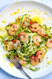 lemon garlic shrimp over zucchini pasta on stone plate