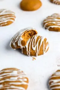 pumpkin cookies with icing on parchment